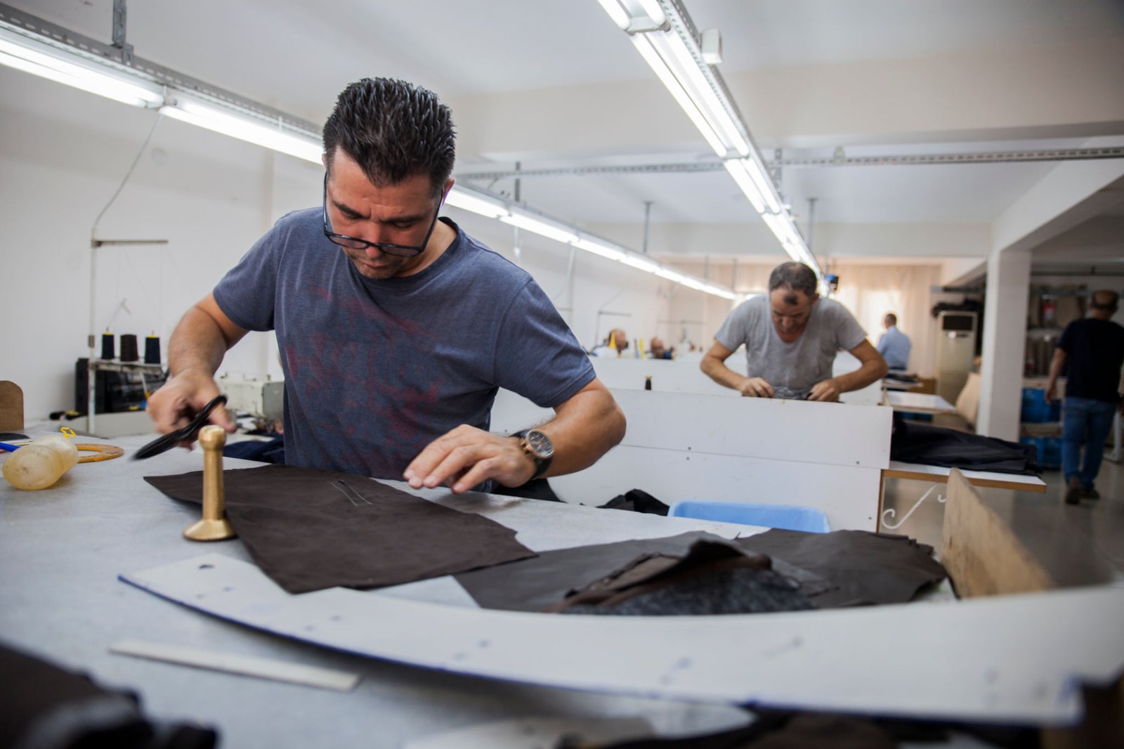 Male Workers Sewing Leather Jackets In Leather Workshop