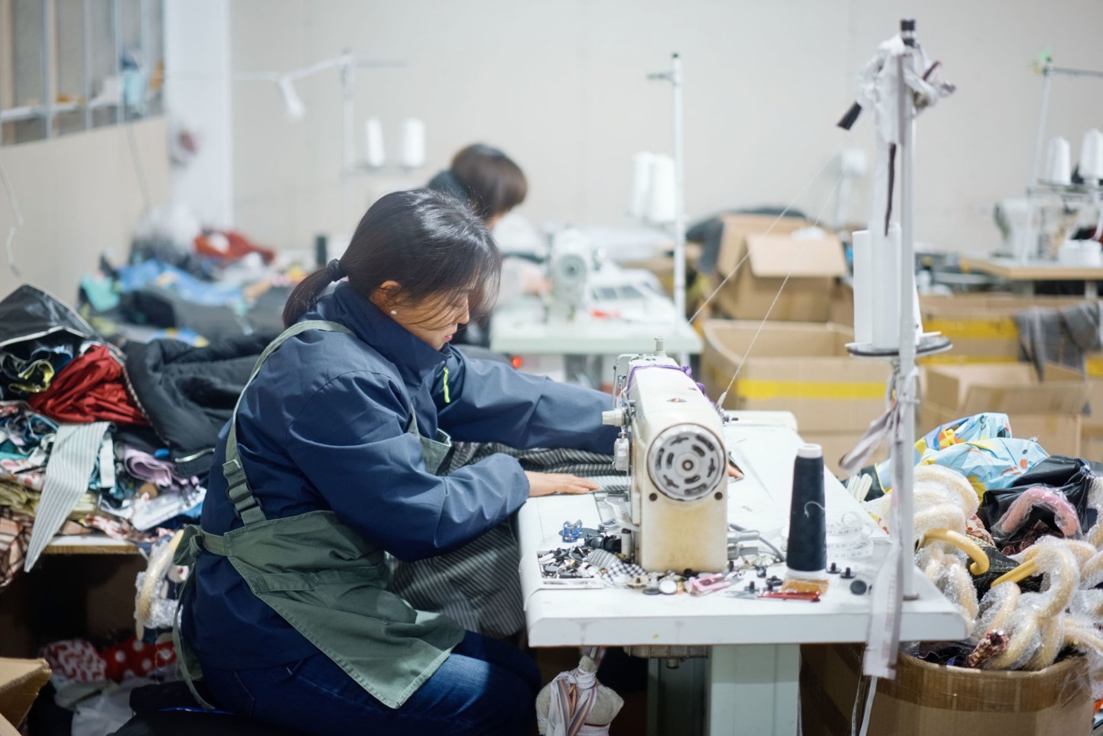 Asian female blue-collar workers are in the sewing workshop.